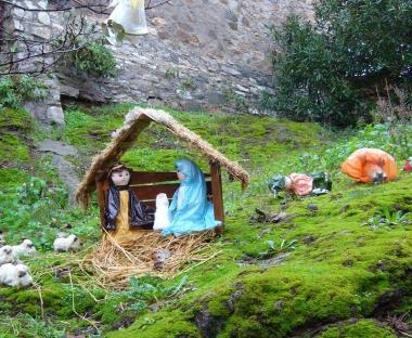 Il presepe dei bambini ricicloni della scuola di Sassetta (a sinistra) e la sacra famiglia su una cassetta postale 