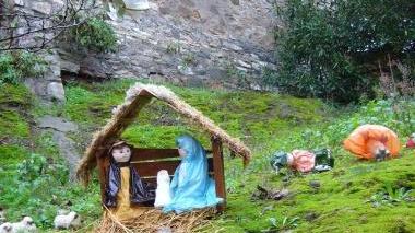 Il presepe dei “bambini ricicloni” della scuola di Sassetta (a sinistra) e la sacra famiglia su una cassetta postale
