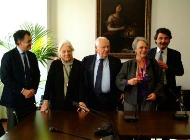 La casa di Puccini (sullo sfondo) e (da sinistra) il notaio Luca Nannini, Simonetta Puccini, Giovanni Cattani, Gabriella Biagi Ravenni e Stefano Baccelli dopo la firma del contratto  