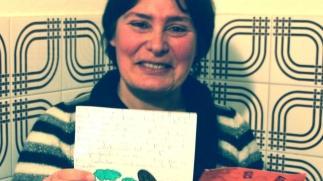 Annalisa Resito mostra la lettera arrivata con 20 anni di ritardo; a destra, la data del bollo