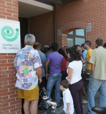 Persone in fila ad un centro per limpiego Sopra, unazienda tessile 