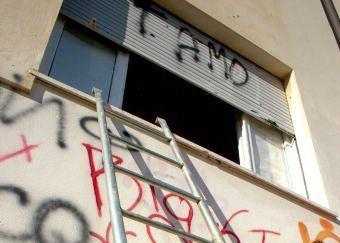Scritte sul muro di una scuola e, a fianco, Franco Rindi