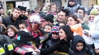 La Befana durante la discesa dal Rivellino aiutata da un vigile del fuoco e durante la distribuzione dei dolci ai bambini