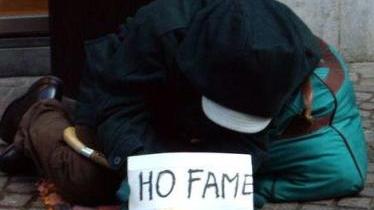 Un mendicante chiede l’elemosina per strada