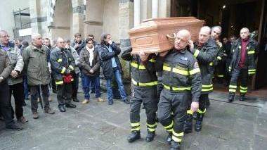 Il feretro viene portato fuori dalla chiesa a spalla dai vigili del fuoco