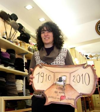 Fulvia Leone nel negozio con linsegna del centenario    