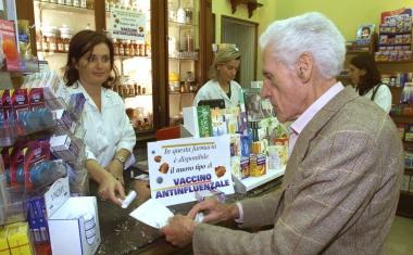 Un cliente si informa sulla campagna anti-influenzale in una farmacia 