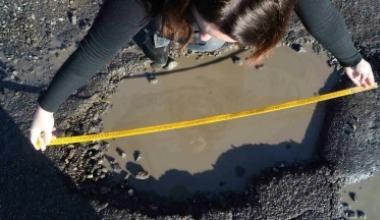 Una delle enormi buche al centro della strada