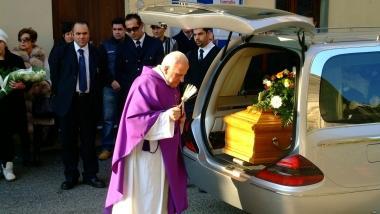 Il parroco benedice la bara e a destra le persone andate a dare lestremo saluto al ragazzo 