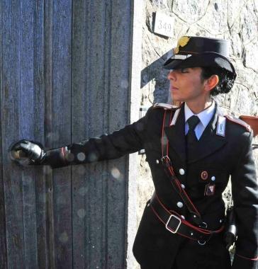 Una militare dell’Arma davanti alla porta dell’abitazione di Giuseppe Milanesi e la via Mammianese che attraversa Prunetta