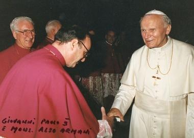 Don Armani stringe la mano a Giovanni Paolo II e con la foto di famiglia del giorno della prima messa 