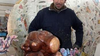 <b>ARRIVANO GLI ALIENI.</b> Luigi Bonetti mostra il modellino del carro A sinistra alcuni mascheroni in fase di preparazione
