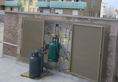 Le bombole del gas sistemate sui pianerottoli dei palazzi ancora privi degli allacci di luce, acqua e metano. Sopra i cavi che trasportano nelle abitazioni l’energia di cantiere. A destra una schiera di palazzine in fase di ultimazione nella seconda parte del primo lotto di Salviano 2, dietro a via Renato Natali