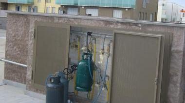 Le bombole del gas sistemate sui pianerottoli dei palazzi ancora privi degli allacci di luce, acqua e metano. Sopra i cavi che trasportano nelle abitazioni l’energia di cantiere. A destra una schiera di palazzine in fase di ultimazione nella seconda parte del primo lotto di Salviano 2, dietro a via Renato Natali