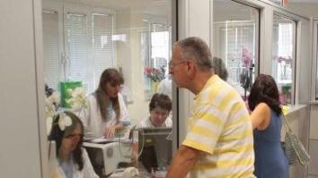 Persone agli sportelli presso una struttura sanitaria
