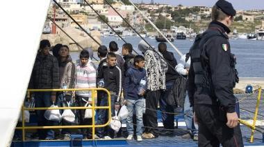 Una squadra della Misericordia di Empoli e più a sinistra un gruppo di tunisini in partenza da Lampedusa