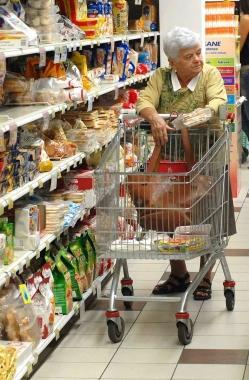 A sinistra: una anziana massaia con il carrello mentre fa la spesa al supermercato