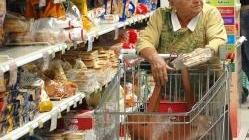 A sinistra: una anziana massaia con il carrello mentre fa la spesa al supermercato