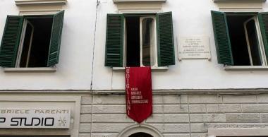 Una delle finestre di casa Mod&igrave; segnalata da un arazzo e una targa 
