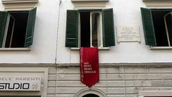 Una delle finestre di casa Modì segnalata da un arazzo e una targa