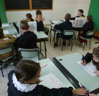 Bambini in classe intenti a scrivere     