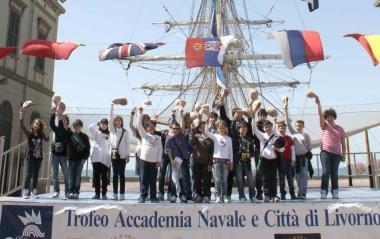 Sara Pacini premiata dal capitano DellOso Sopra foto di gruppo davanti al brigantino nel cortile dellAccademia Navale 