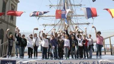 Sara Pacini premiata dal capitano Dell’Oso Sopra foto di gruppo davanti al brigantino nel cortile dell’Accademia Navale