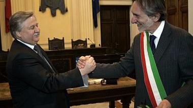 La stretta di mano tra i sindaci e, a destra, gli ospiti russi in municipio