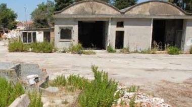 Una ruspa fra le macerie dopo la demolizione e sopra come era l’area prima dell’intervento