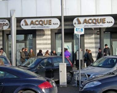 Persone in attesa di entrare negli uffici di Acque Spa 