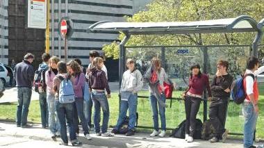 Passeggeri in attesa di un autobus all’ora di punta in una fermata del centro storico