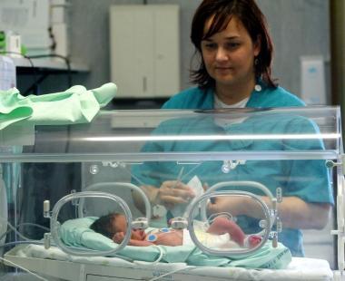Infermiera assiste un neonato 
