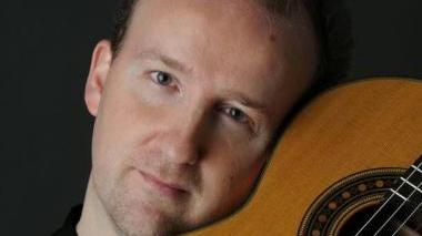 Pegoraro con la sua chitarra in primo piano
