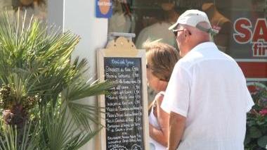 <b>CONCORRENZA.</b> Un cliente osserva un menù fuori dal bagno