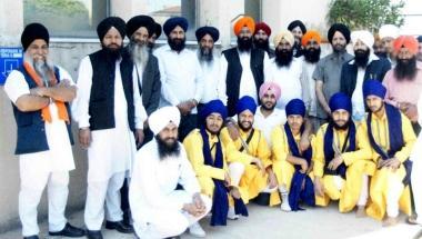 In alto un gruppo di sikh riuniti in porto  