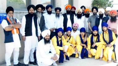 In alto un gruppo di sikh riuniti in porto