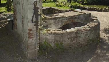 Lantico lavatoio che circonda il pozzo la cui acqua risulta inquinata. Accanto il muro di cinta che &egrave; stato puntellato  