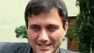 L’avvocato Giacomo Bugliani difensore del parroco e a fianco uno striscione apparso nella canonica di Turano