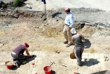 A sinistra i pilastri del ponte e sopra gli archeologi impegnati negli scavi 