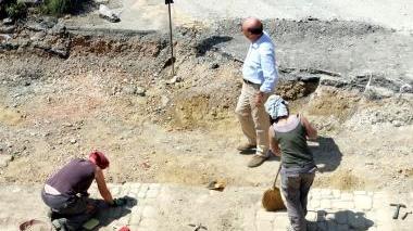 A sinistra i pilastri del ponte e sopra gli archeologi impegnati negli scavi