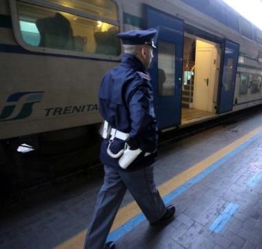 Un agente della polizia ferroviaria intervenuta sul posto; a destra, i binari della stazione dei treni a Pontedera dove &egrave; sceso luomo 