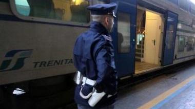Un agente della polizia ferroviaria intervenuta sul posto; a destra, i binari della stazione dei treni a Pontedera dove è sceso l’uomo