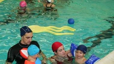 Bambini alle prese con le prime lezioni della scuola di nuoto