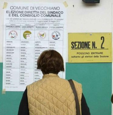 Sopra un seggio durante il voto e un manifesto elettorale 