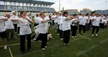 Un gruppo di anziani fa ginnastica dentro lo stadio 