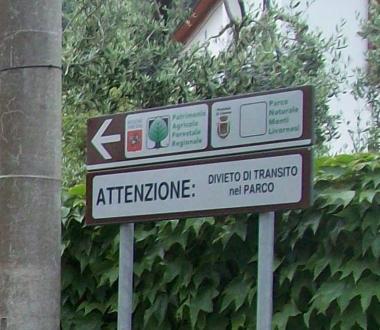 A sinistra lindicazione del Parco dei monti livornesi. Accanto il cancello privato che impedisce lingresso alla strada 