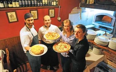 Lo staff al completo della pizzeria Antico Rio e Tiziano Foddis mentre versa una delle birre artigianali toscane   