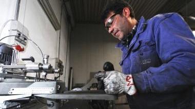 Un fabbro al lavoro, a destra Donato Rubino e Enrico Bonfanti