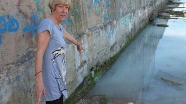 Una signora mostra il tubo da dove è uscita la vernice