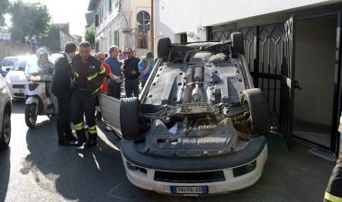 Sopra, la Golf ribaltata sul marciapiede di via Gramsci; a lato, un vigile del fuoco nell’abitacolo dell’auto ribaltata; a destra il conducente illeso dopo l’incidente
